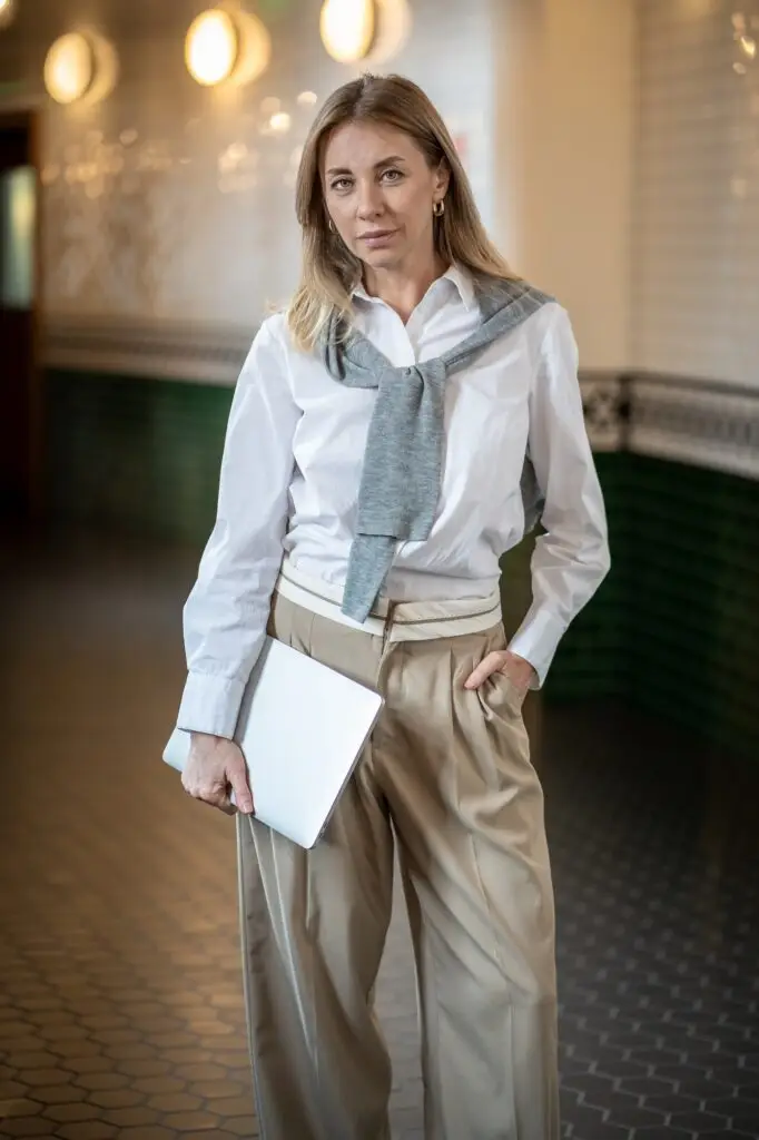 Independent professional businesswoman in corridor carrying laptop. Remote digital job, mobility