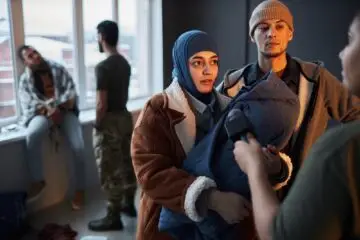 Middle Eastern Refugee Couple Giving Interview in Shelter